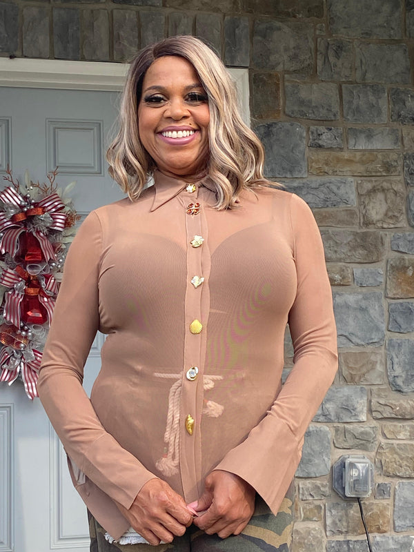 Sheer long sleeve blouse with jeweled button closures.
